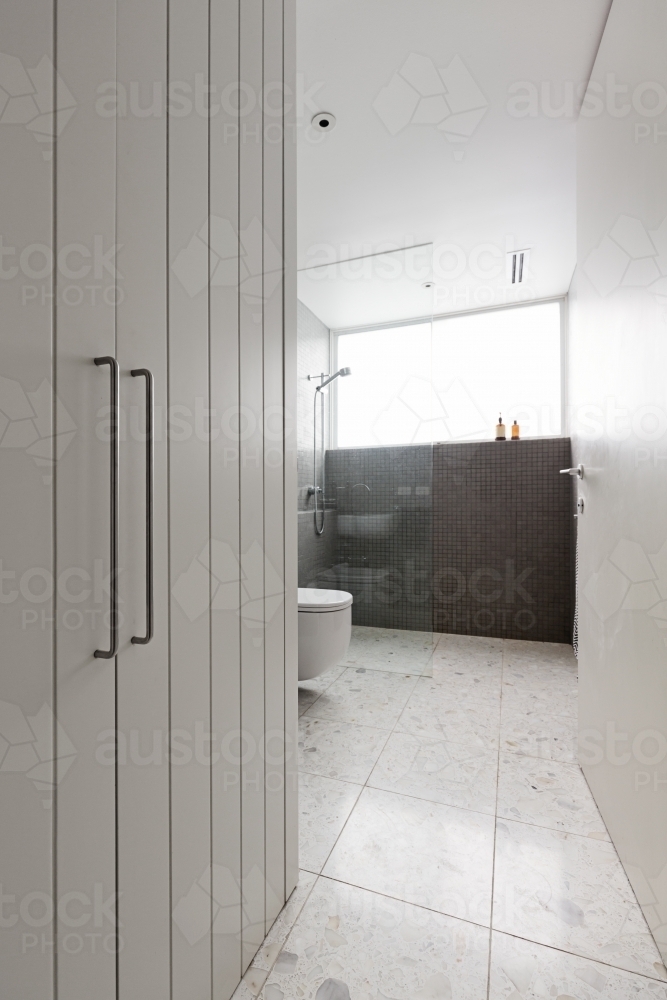 Contermporary bathroom of mosaic tiles and walk in shower with storage cupboard - Australian Stock Image