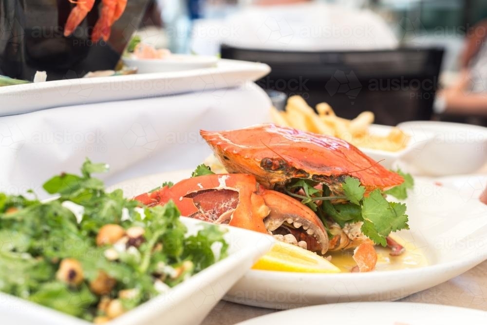 cooked mudcrab lunch, with salad in the foreground - Australian Stock Image