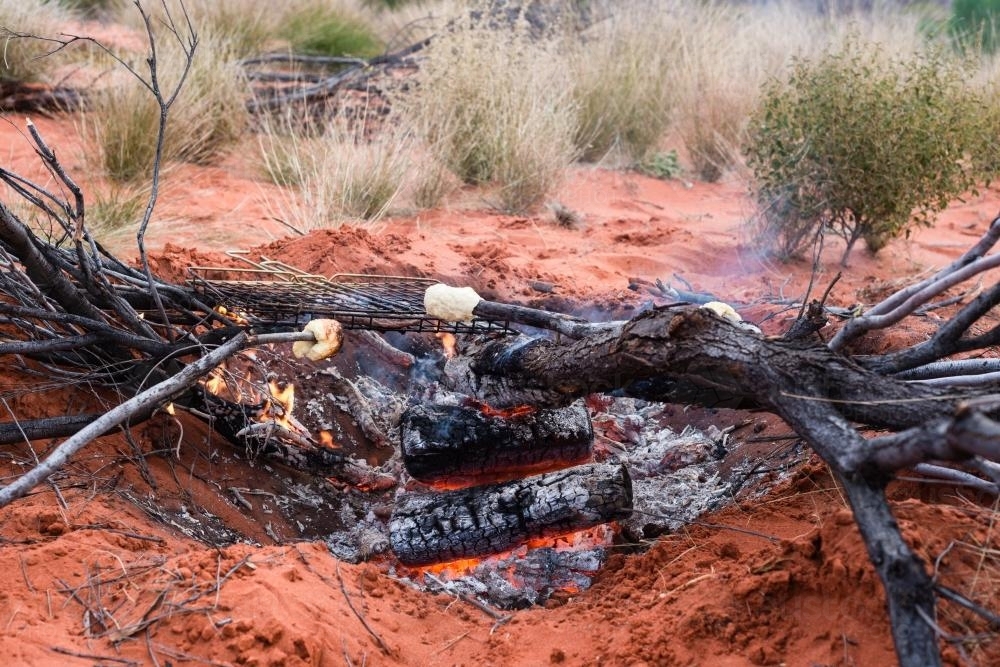 Cooking damper over an open fire in Outback Australia - Australian Stock Image
