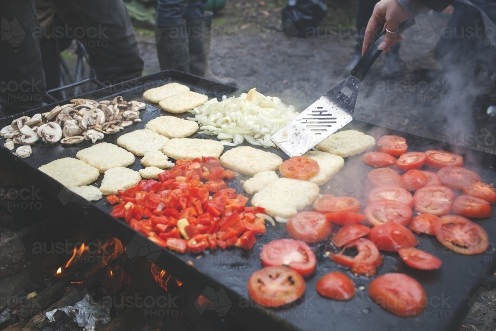 Cooking outdoor camping breakfast on campfire hot plate - Australian Stock Image