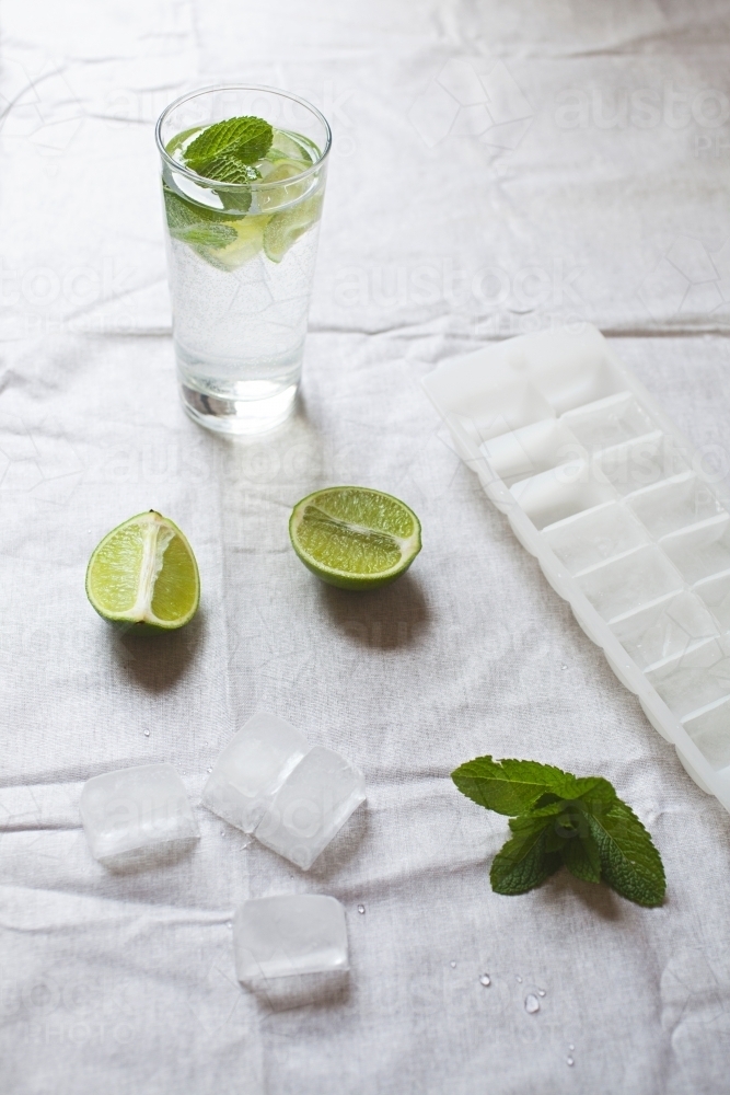 Cool glass of water with ice and mint on tabletop - Australian Stock Image