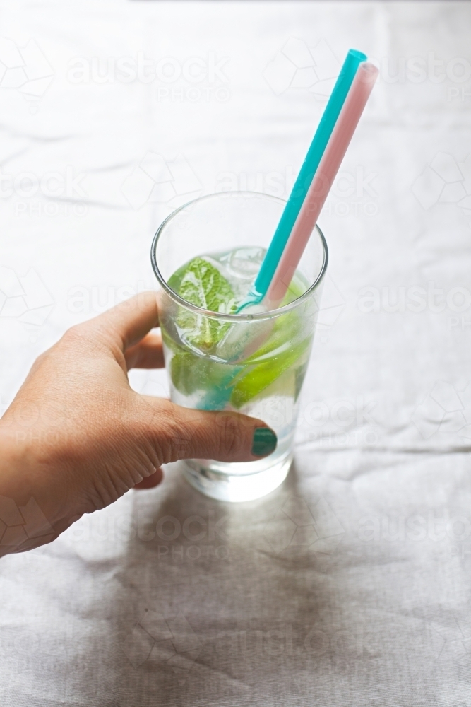 Cool glass of water with ice and mint on tabletop - Australian Stock Image
