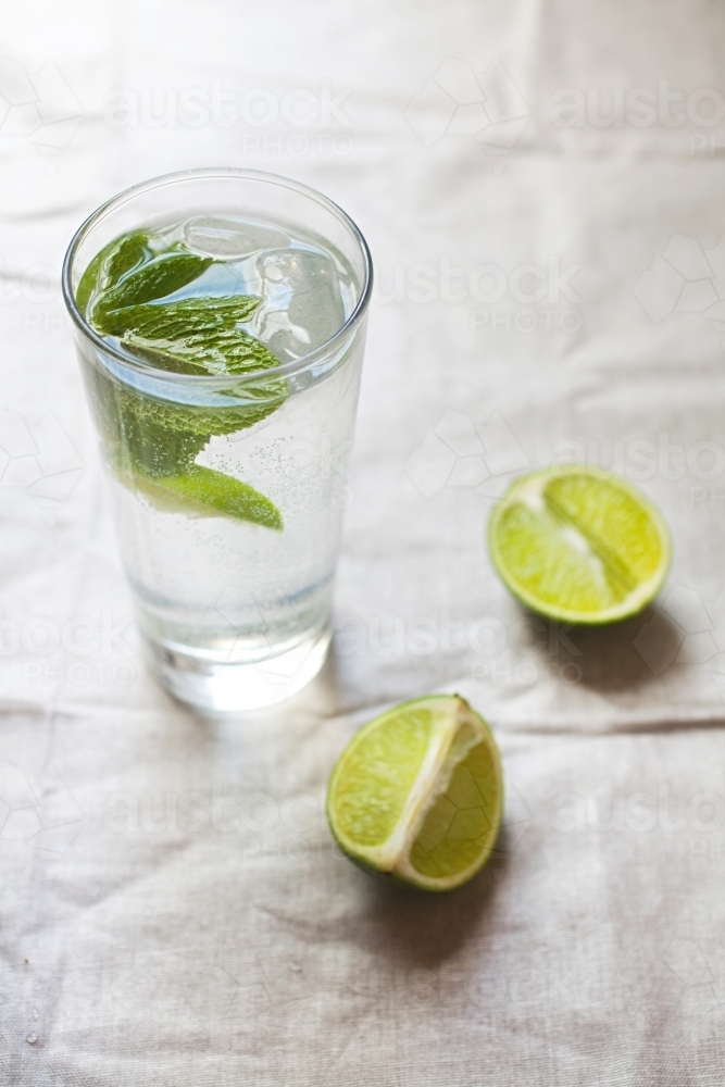 Cool glass of water with ice and mint on tabletop - Australian Stock Image