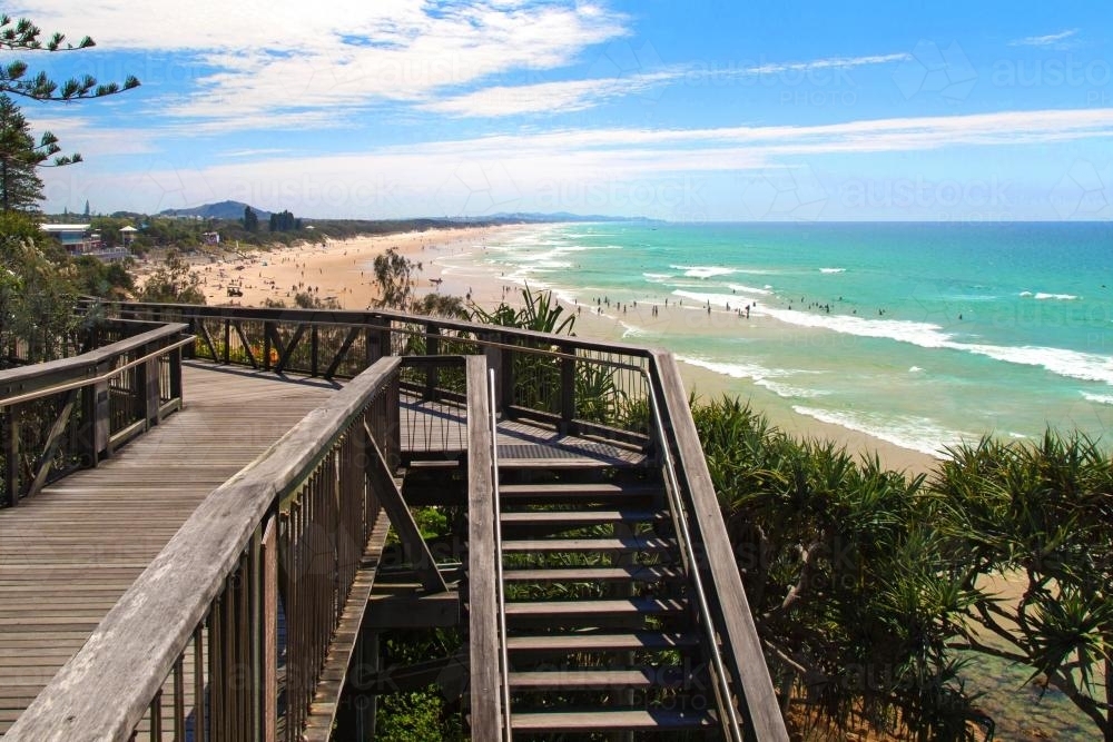 Coolum Beach wooden boardwalk looking over green sea - Australian Stock Image