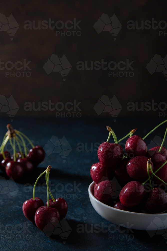copy space above red cherries on a plate - Australian Stock Image