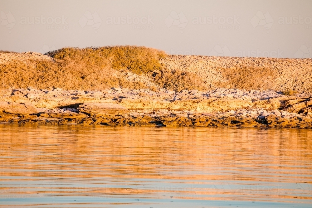 Coral island at the Abrolhos Islands at sunset with warm golden colours - Australian Stock Image