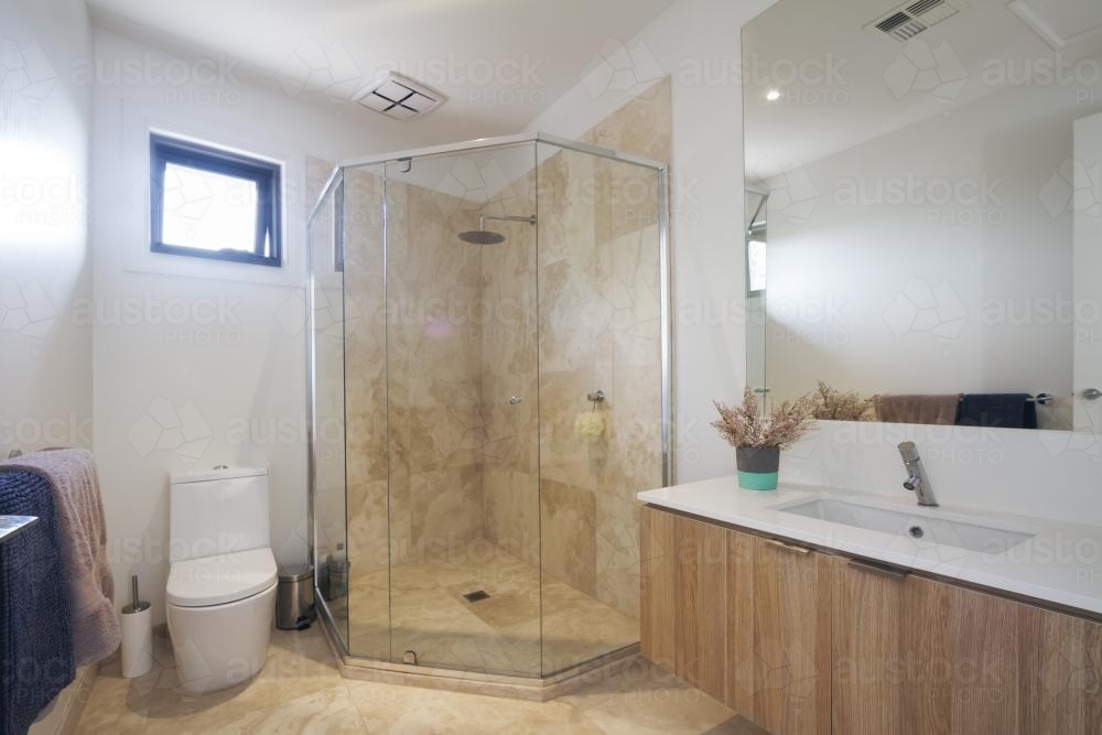 Corner shower marble tiling in contemporary bathroom in luxury house - Australian Stock Image
