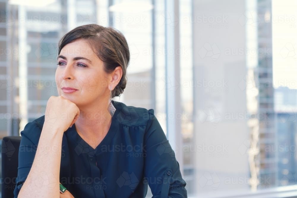 Corporate business woman sitting in city office boardroom - Australian Stock Image