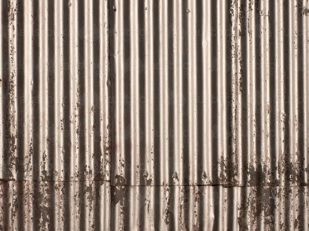 Corrugated iron wall with worn silver paint work - Australian Stock Image