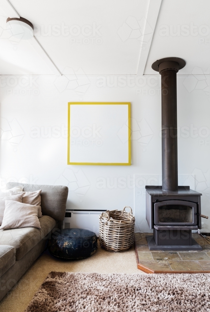 Cosy retro 70s style living room detail of wood heater and shag pile rug - Australian Stock Image