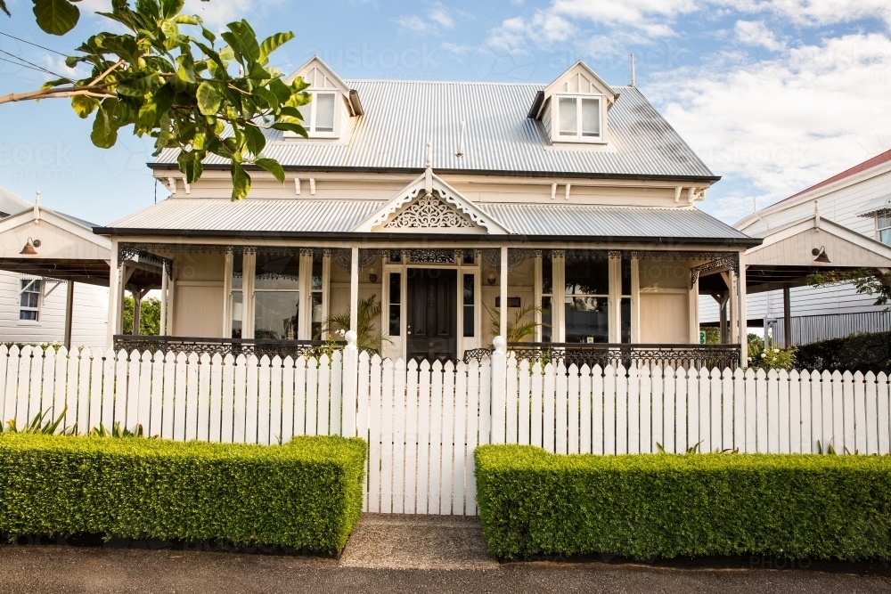 cottage with dormer windows and a white picket fence in Brisbane - Australian Stock Image