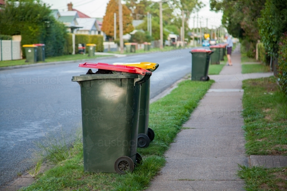 Council rubbish bins awaiting collection along town road - Australian Stock Image