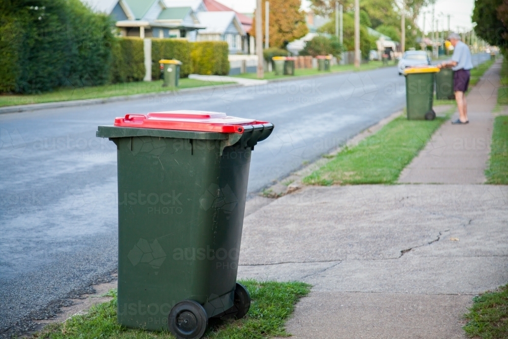 Council rubbish bins awaiting collection along town road - Australian Stock Image