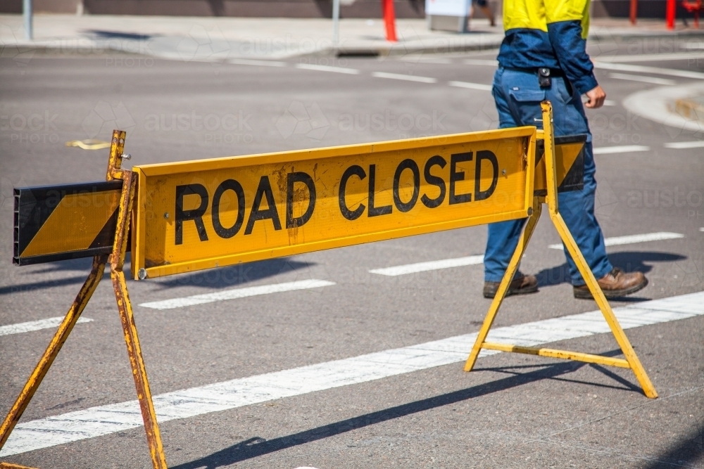 Council worker walking past road closed sign - Australian Stock Image
