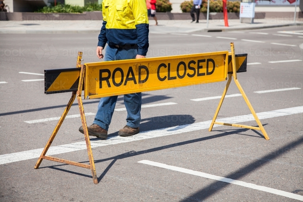 Council worker walking past road closed sign - Australian Stock Image