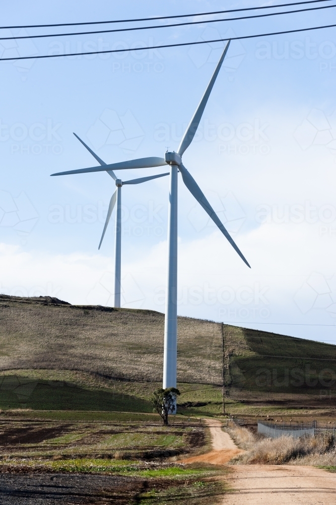 Country road leading past wind turbines - Australian Stock Image