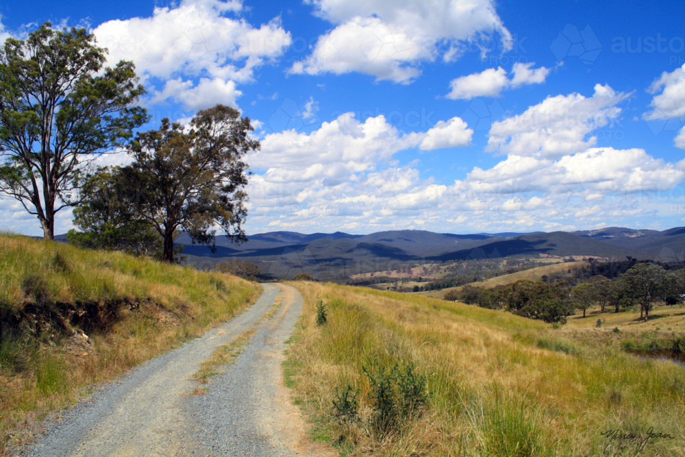 Country road with blue sky and mountains - Australian Stock Image