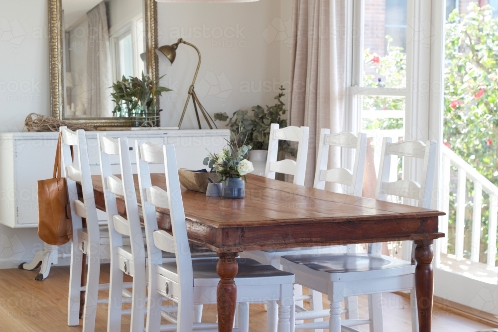 Country style dining room with wooden floor and windows to verandah - Australian Stock Image
