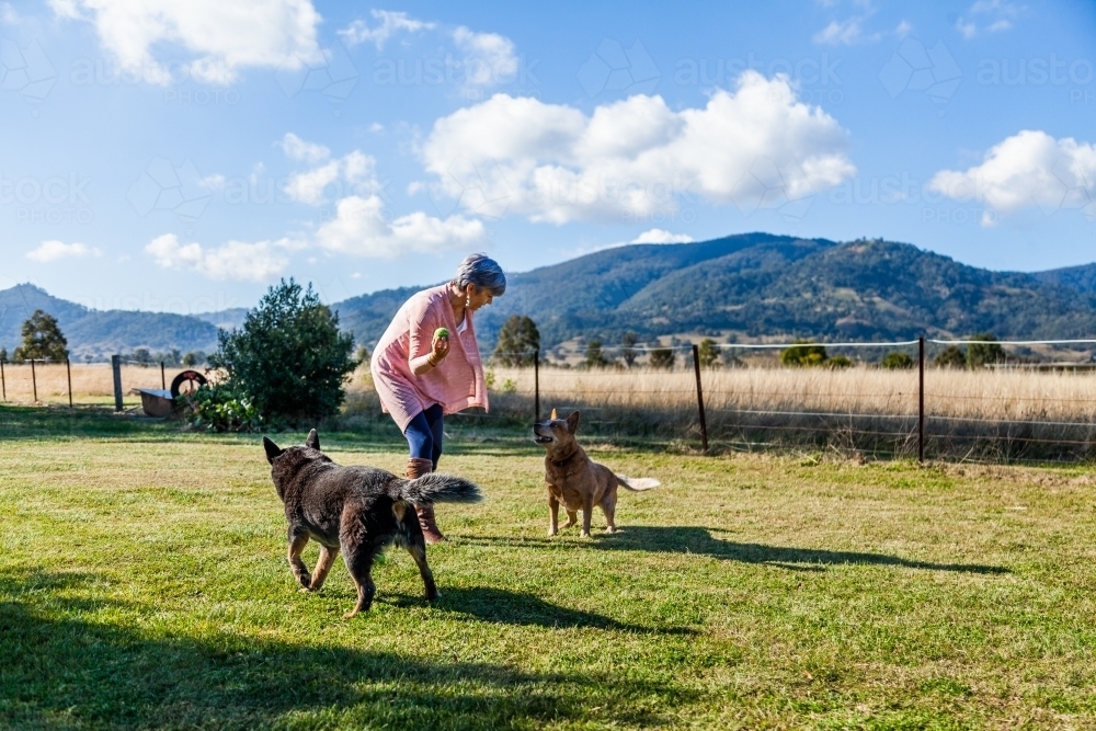 Country woman playing with her pet doge on rural property - Australian Stock Image