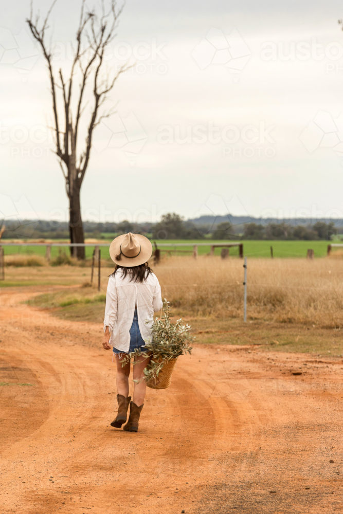 Country woman walking along dirt road - Australian Stock Image