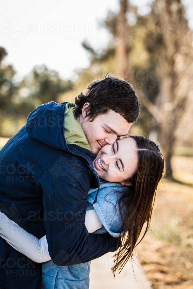 Couple cuddling and nuzzling laughing - Australian Stock Image