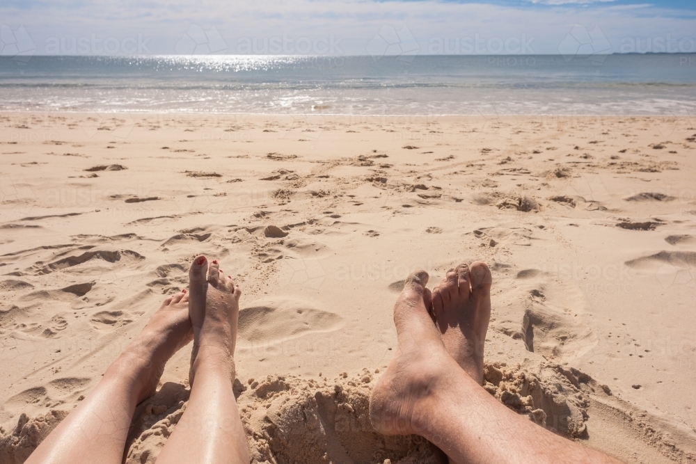 Couple enjoying some sunshine at a remote beach - Australian Stock Image