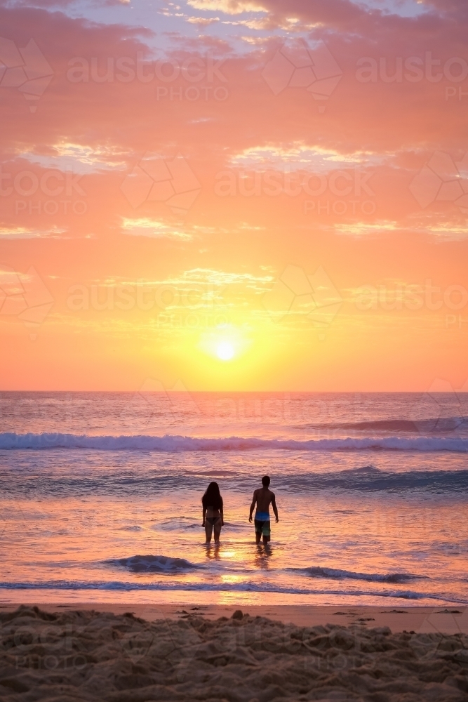 Couple in the water at sunrise - Australian Stock Image