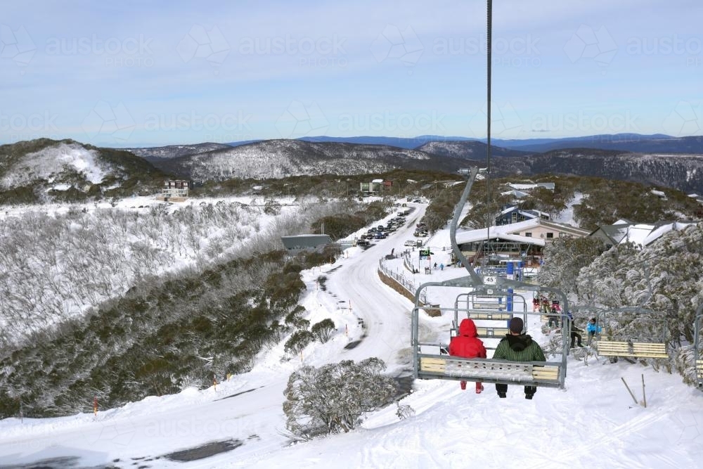 Couple on a chair lift in the snow - Australian Stock Image