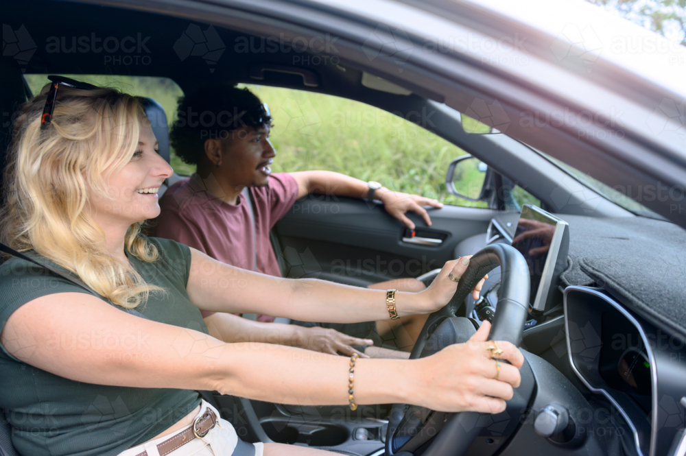 Couple on a road trip, woman driving the car - Australian Stock Image