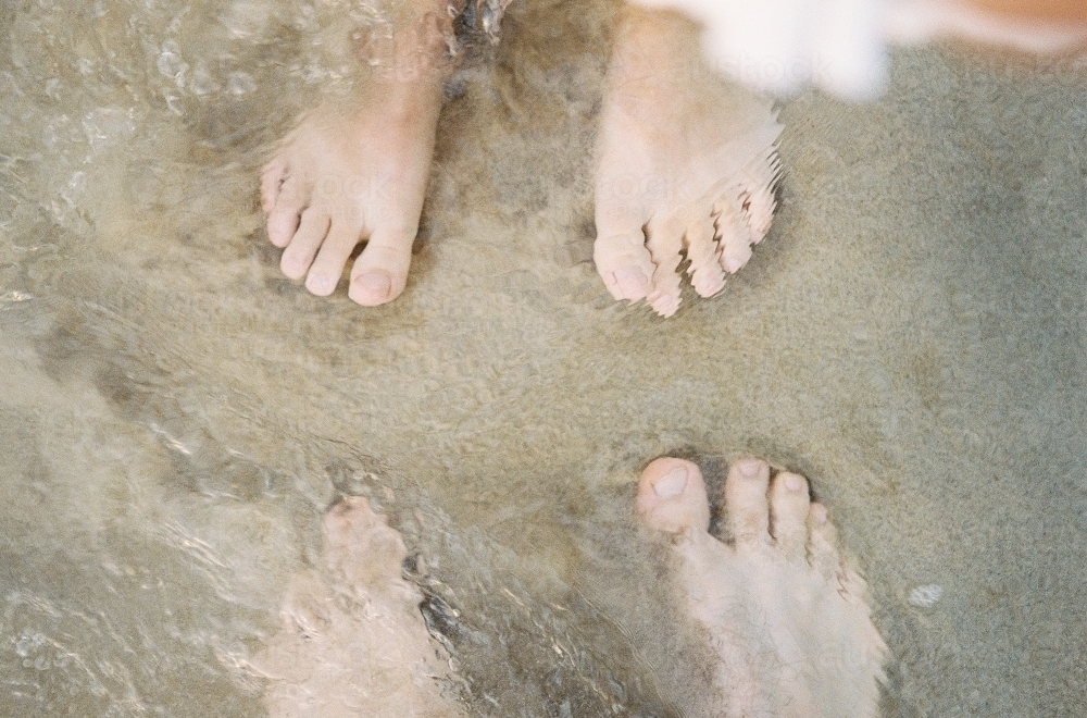 Couple's Feet in the Water on Beach - Australian Stock Image