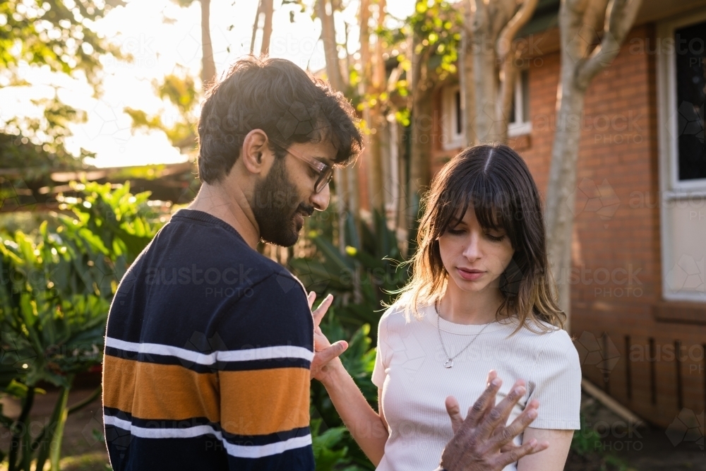 couple showing signs of emotion as they stand together - Australian Stock Image