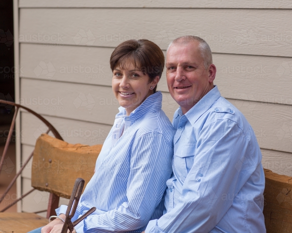 couple sitting together on bench - Australian Stock Image