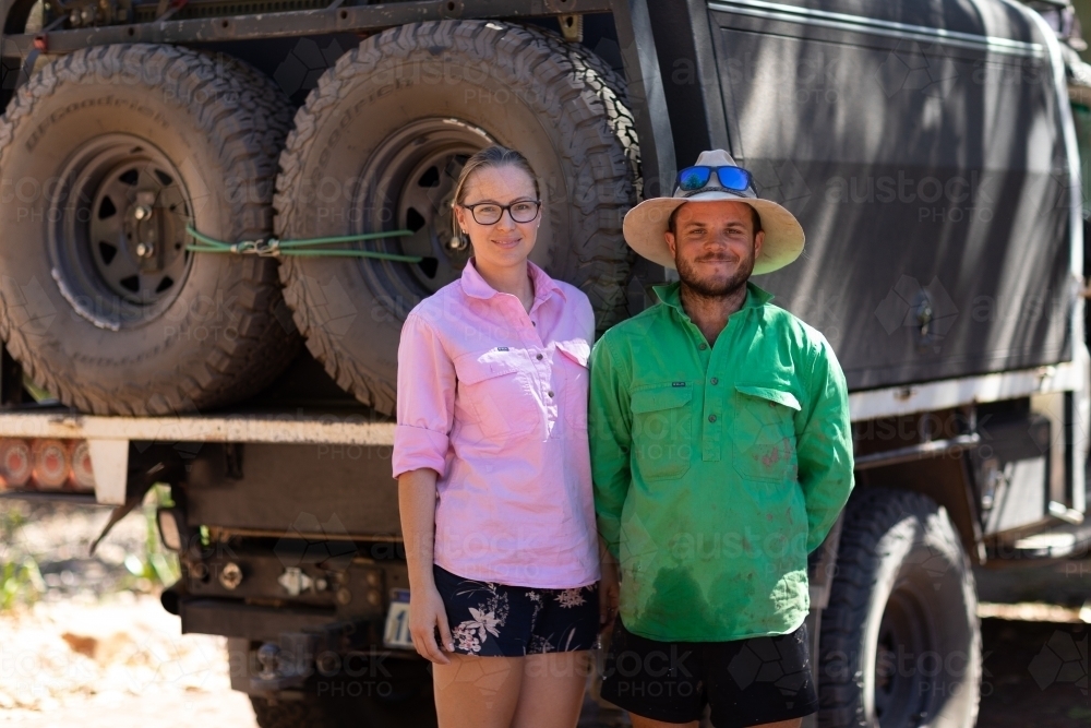 couple standing beside their 4WD vehicle on outback trip - Australian Stock Image