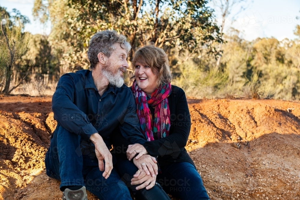 Couple talking together sitting down after bushwalk - Australian Stock Image