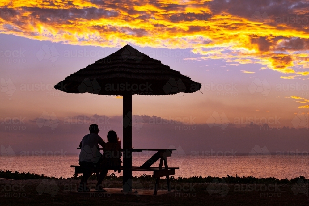 Couple watching sunset at Cape Gloucester. - Australian Stock Image