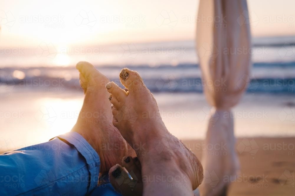 couples feet together in a romantic setting at the beach - Australian Stock Image