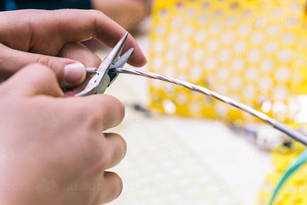 craft time, girl cutting wire with pliers - Australian Stock Image