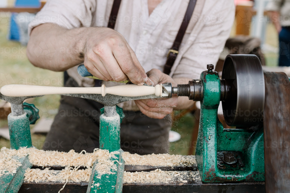 Craftsman shaping wooden spindle on traditional wood lathe machine - Australian Stock Image