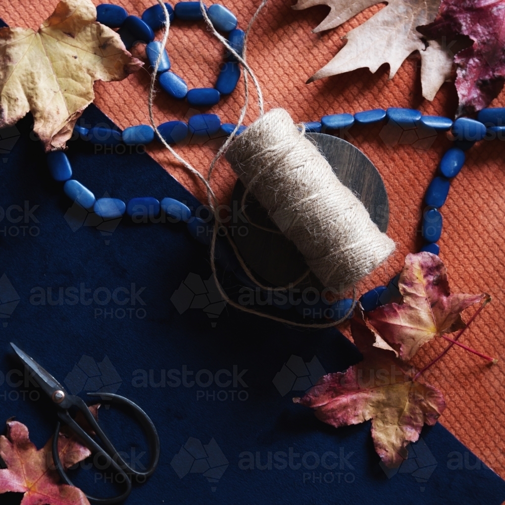 Crafty background of autumn objects on navy and orange - Australian Stock Image
