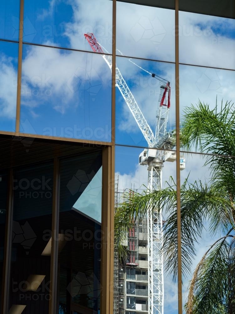 Crane and construction reflected in mirrored exterior of a building - Australian Stock Image