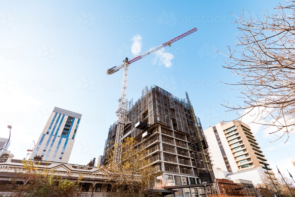 Crane working atop building under construction in Adelaide CBD - Australian Stock Image