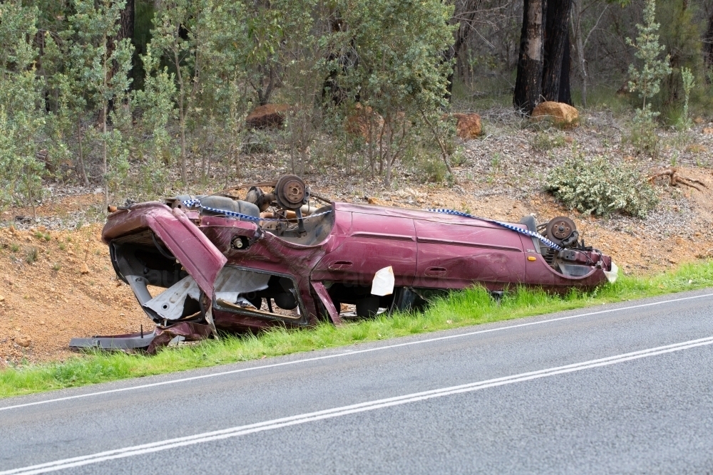 Crashed car upside down on side of country road - Australian Stock Image