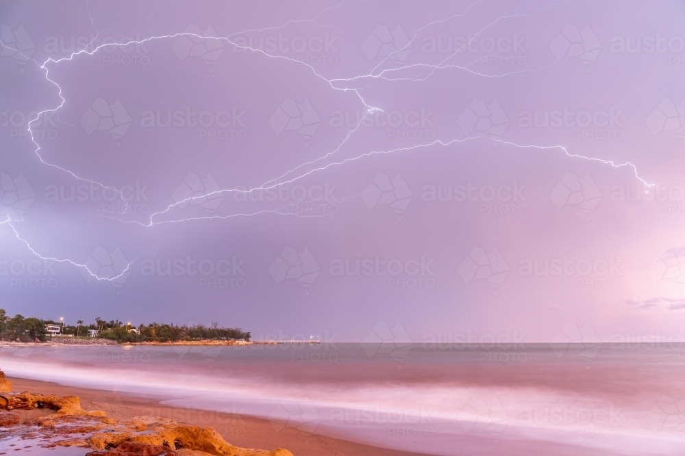 Crawler lightning over Nightcliff Jetty at sunrise with pink sky - Australian Stock Image