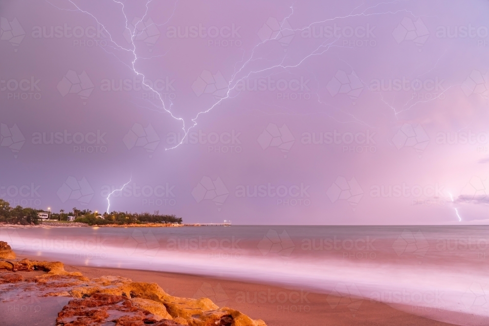 Crawler lightning over Nightcliff Jetty at sunrise with pink sky - Australian Stock Image