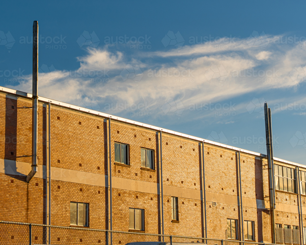 Image of Cream brick building against a blue sky - Austockphoto