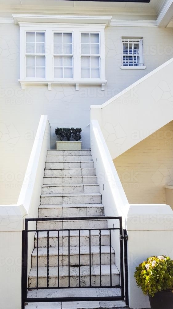 Cream coloured building with black gate and stairs - Australian Stock Image