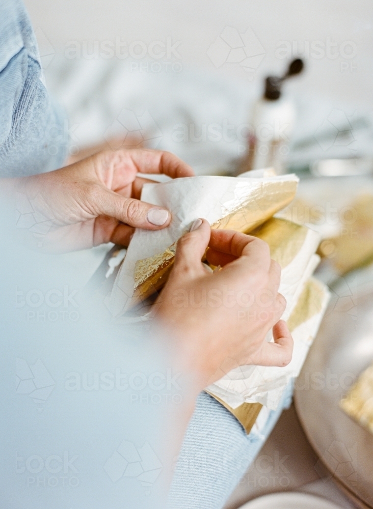 Creative painter working with gold leaves - Australian Stock Image
