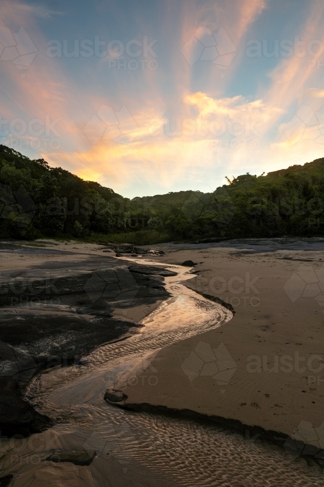 Creek flowing on Dudley beach at sunset - Australian Stock Image