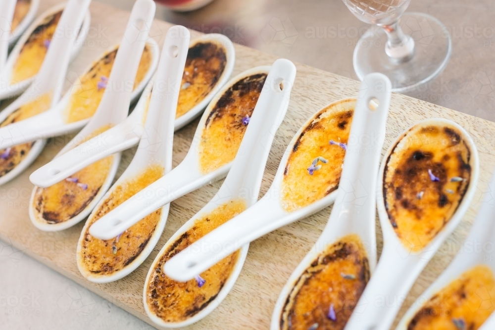 creme brulee in individual spoons - Australian Stock Image