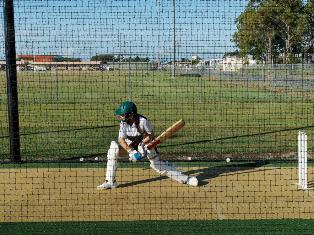 Cricket training and practice in the nets for left handed female cricket player - Australian Stock Image